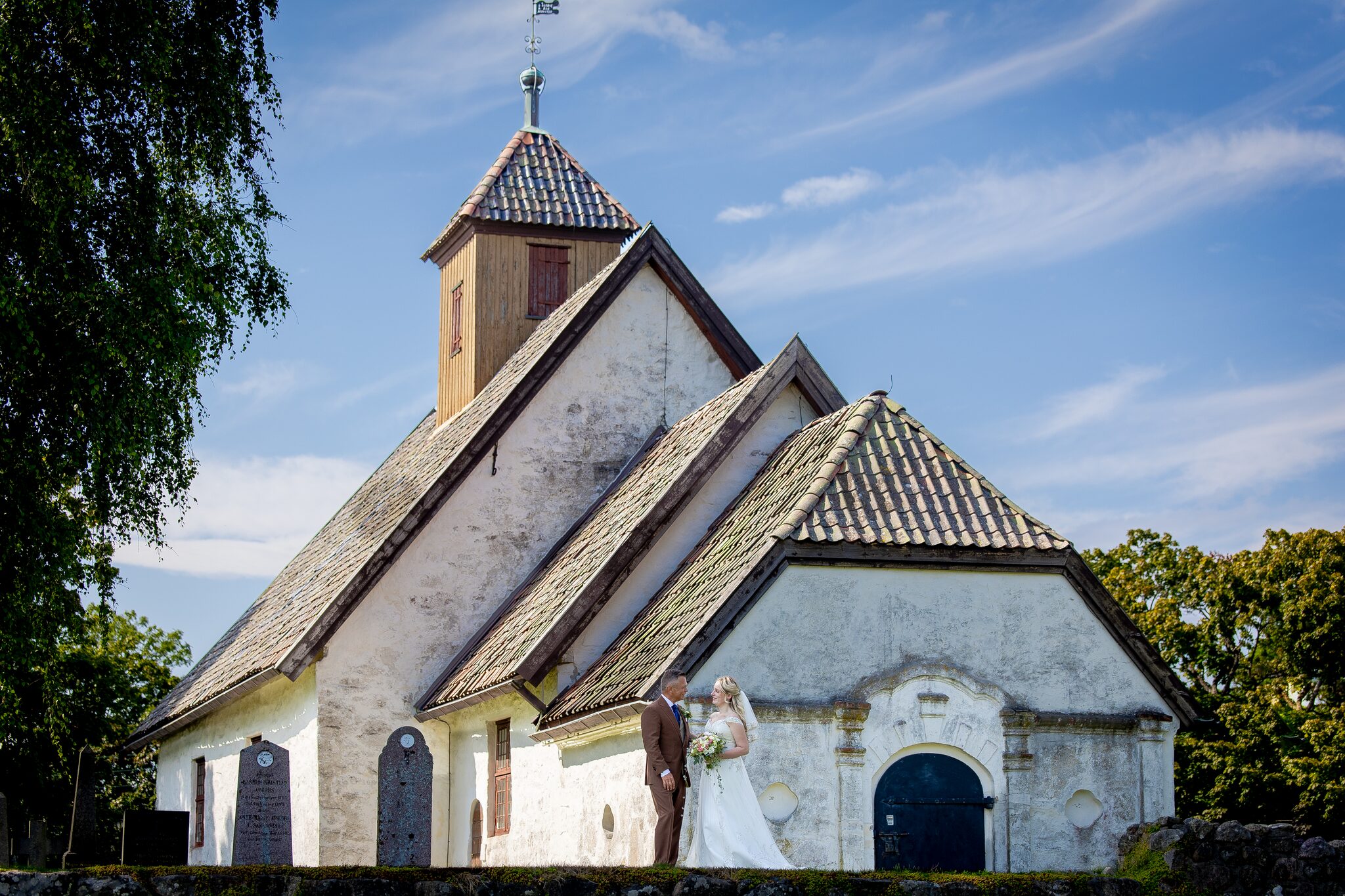 Bryllupsfotograf Østfold – brudepar foran steinkirke